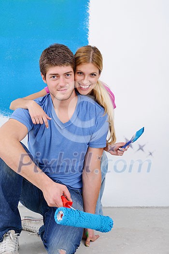happy young couple paint in green and blue color white wall of their new home happy young couple paint in green and blue color white wall of their new home