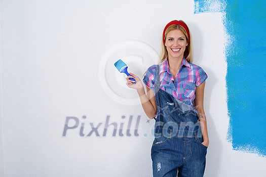 happy smiling woman painting interior white wall in blue and green color of new house happy smiling woman painting interior white wall in blue and green color of new house