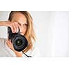 Pretty, female photographer with digital camera - DSLR and a huge telephoto lens (color toned image; shallow DOF)