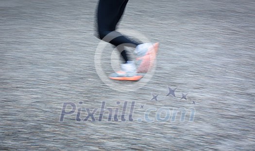 Motion blurred runner's feet in a city environment (panning technique used -> motion blurred image; color toned image) Motion blurred runner's feet in a city environment (panning technique used -> motion blurred image; color toned image)