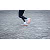 Motion blurred runner's feet in a city environment (panning technique used -> motion blurred image; color toned image)