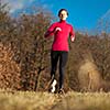 Young woman running outdoors on a lovely sunny winter/fall day