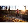 Young woman running outdoors in a city park on a cold fall/winter day (motion blurred image)