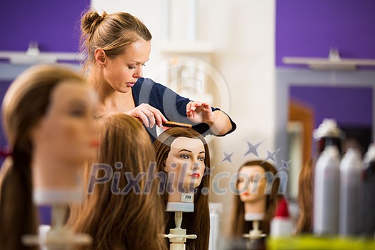 Pretty female hairdresser/haidressing apprentice/student training on an apprentice head Pretty female hairdresser/haidressing apprentice/student training on an apprentice head