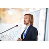 Handsome young man giving a speech at a conference