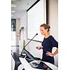 Pretty, young business woman giving a presentation in a conference/meeting setting (shallow DOF; color toned image)