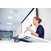 Pretty, young business woman giving a presentation in a conference/meeting setting (shallow DOF; color toned image)