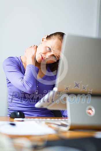 Working too hard - young woman working on a computer at an office, having sore back, being overloaded with work, sitting too much, putting too much stress on her eyes,.. Working too hard - young woman working on a computer at an office, having sore back, being overloaded with work, sitting too much, putting too much stress on her eyes,..