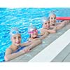 group of happy kids children   at swimming pool class  learning to swim