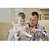 father and son assembling airplane toy at modern home living room indoor