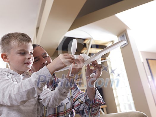 father and son assembling airplane toy at modern home living room indoor father and son assembling airplane toy at modern home living room indoor