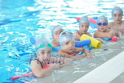 group of happy kids children at swimming pool class learning to swim group of happy kids children at swimming pool class learning to swim