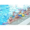 group of happy kids children   at swimming pool class  learning to swim