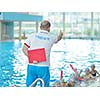 group of happy kids children   at swimming pool class  learning to swim