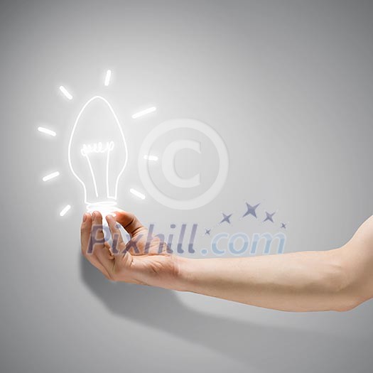 Close up image of human hand holding electrical bulb Close up image of human hand holding electrical bulb
