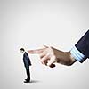 Close up of male businessman pointing at miniature of man