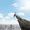 Young businessman sitting on edge of rock