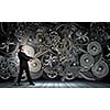 Young businessman fixing gears mechanism with wrench