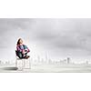 Young girl sitting in chair against city background