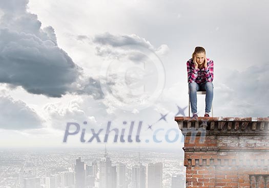 Young woman in casual sitting on in chair on top of building Young woman in casual sitting on in chair on top of building