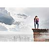 Young woman in casual sitting on in chair on top of building
