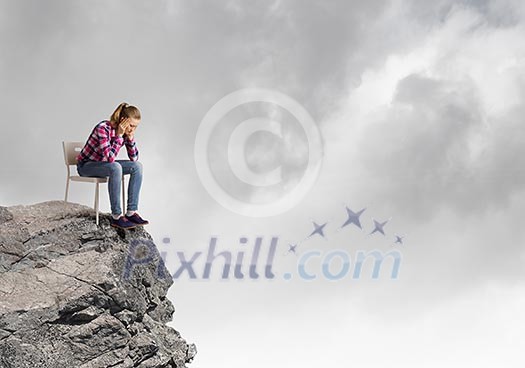 Young woman in casual sitting in chair on top of rock Young woman in casual sitting in chair on top of rock