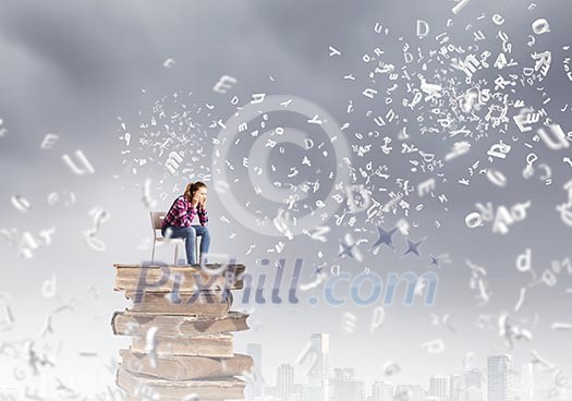 Young girl sitting on high pile of books Young girl sitting on high pile of books