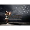 Young woman sitting on bench and playing violin