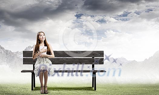 Young pretty asian woman sitting on bench and reading book Young pretty asian woman sitting on bench and reading book