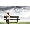Young pretty asian woman sitting on bench and reading book