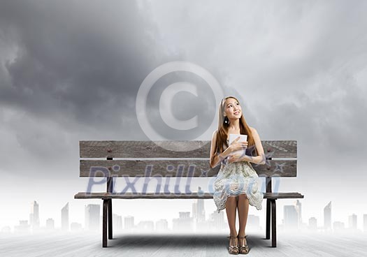 Young pretty asian woman sitting on bench and reading book Young pretty asian woman sitting on bench and reading book