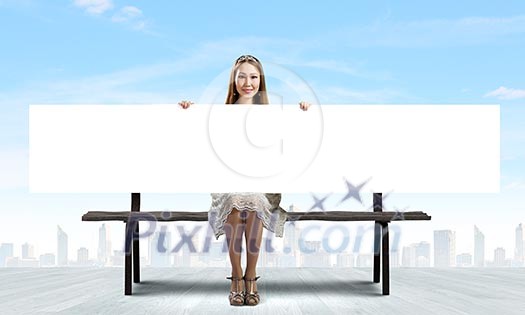 Young asian woman sitting on bench with blank banner Young asian woman sitting on bench with blank banner