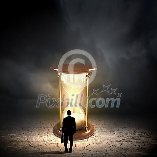 Conceptual image with sandglass and rear view of businessman Conceptual image with sandglass and rear view of businessman