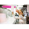 Pretty, young woman choosing the right light for her apartment in a modern home furnishings store (color toned image; shallow DOF)