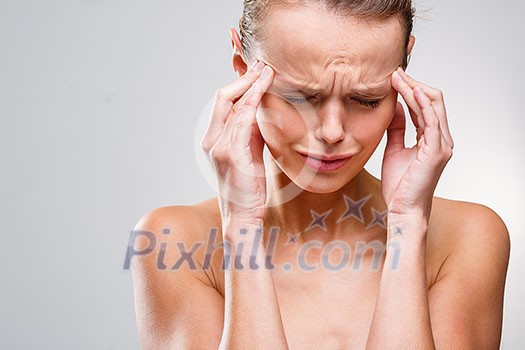 Beautiful woman suffering from acute headache over grey clean background Beautiful woman suffering from acute headache over grey clean background