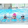 group of happy kids children   at swimming pool class  learning to swim