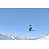 jumping freestyle skier at mountain with fresh snow fresh sunny winter day