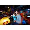 happy father and son playing driving wheel video game in playground theme park
