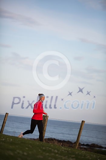 Young woman on her evening jog along the seacoast Young woman on her evening jog along the seacoast