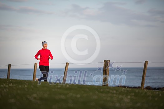 Young woman on her evening jog along the seacoast Young woman on her evening jog along the seacoast