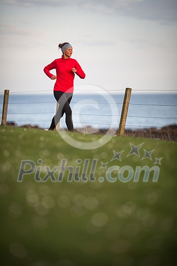 Young woman on her evening jog along the seacoast Young woman on her evening jog along the seacoast