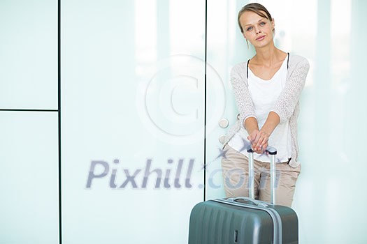 Young female passenger at the airport, about to check-in Young female passenger at the airport, about to check-in