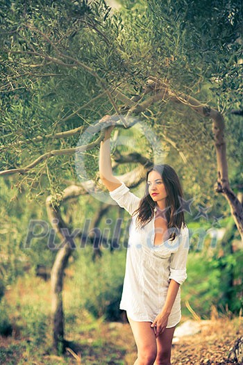 Attractive, young brunette on the beach, amid olive trees, looking both sensual and natural Attractive, young brunette on the beach, amid olive trees, looking both sensual and natural