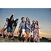 Group of young people enjoy summer  party at the beach on beautiful sunset