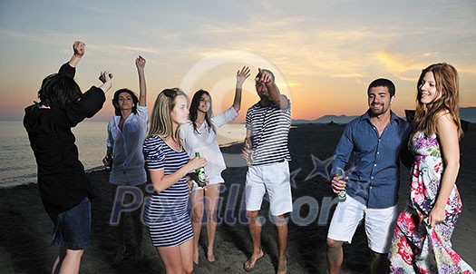 Group of young people enjoy summer party at the beach on beautiful sunset Group of young people enjoy summer party at the beach on beautiful sunset