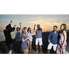 Group of young people enjoy summer  party at the beach on beautiful sunset