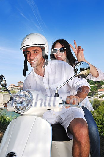 Portrait of happy young love couple on scooter enjoying themselves in a park at summer time Portrait of happy young love couple on scooter enjoying themselves in a park at summer time