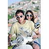 Portrait of happy young love couple on scooter enjoying themselves in a park at summer time