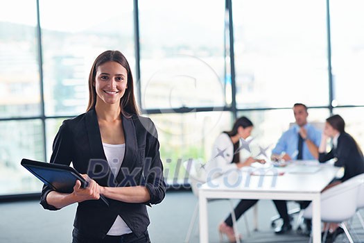happy young business woman with her staff, people group in background at modern bright office indoors happy young business woman with her staff, people group in background at modern bright office indoors