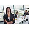 happy young business woman  with her staff,  people group in background at modern bright office indoors